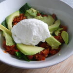 Poached egg with avocado, spinach and spicy tomato sauce